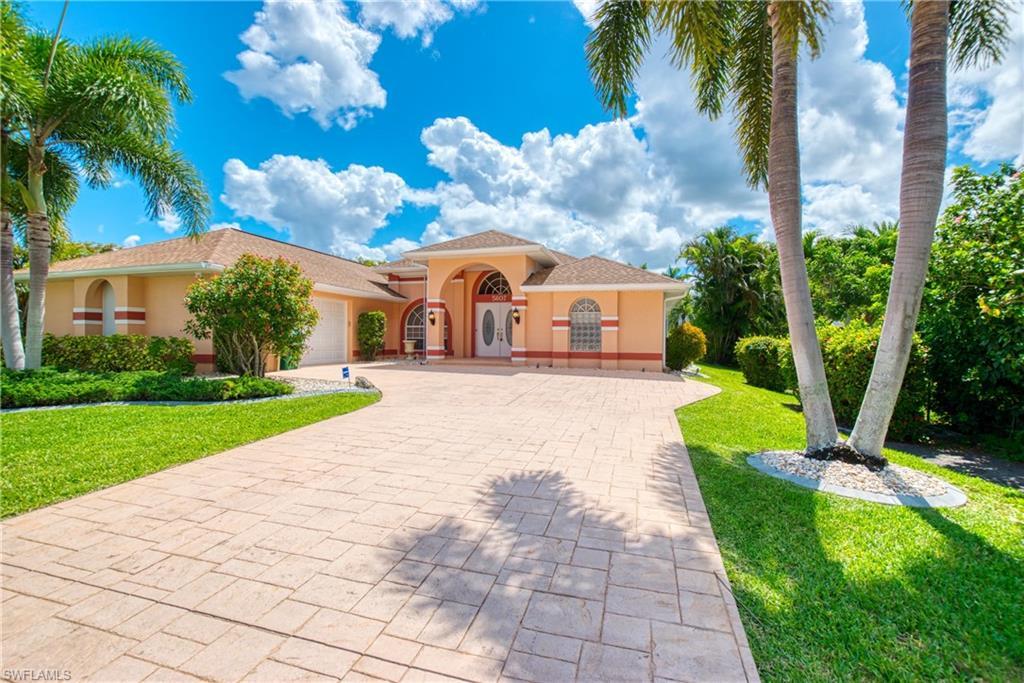Image 2: Mediterranean / spanish-style house featuring decorative driveway, a front lawn, stucco siding, and an attached garage