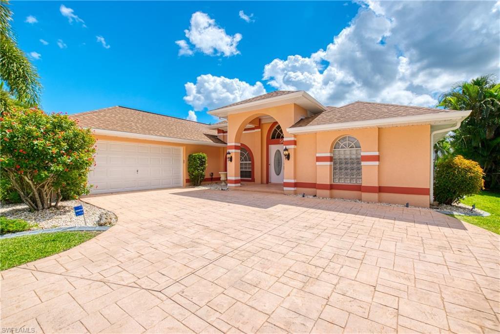 Image 3: Mediterranean / spanish house with decorative driveway, an attached garage, stucco siding, and a shingled roof