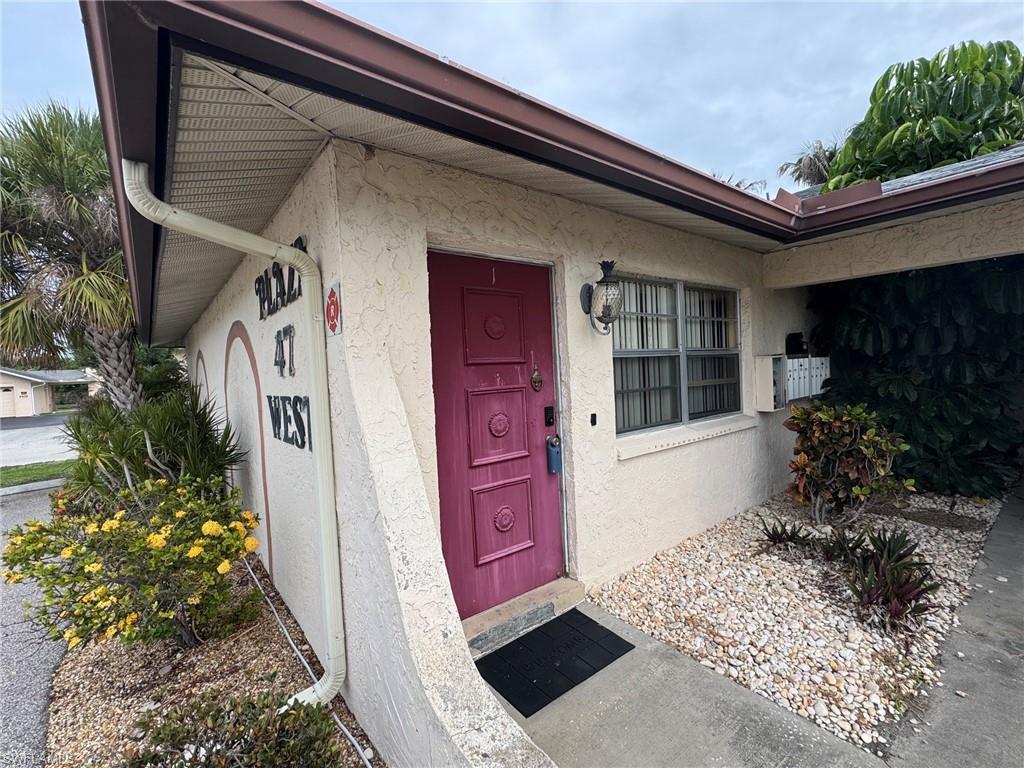 Image 3: Stucco exterior with a bold magenta entry door.