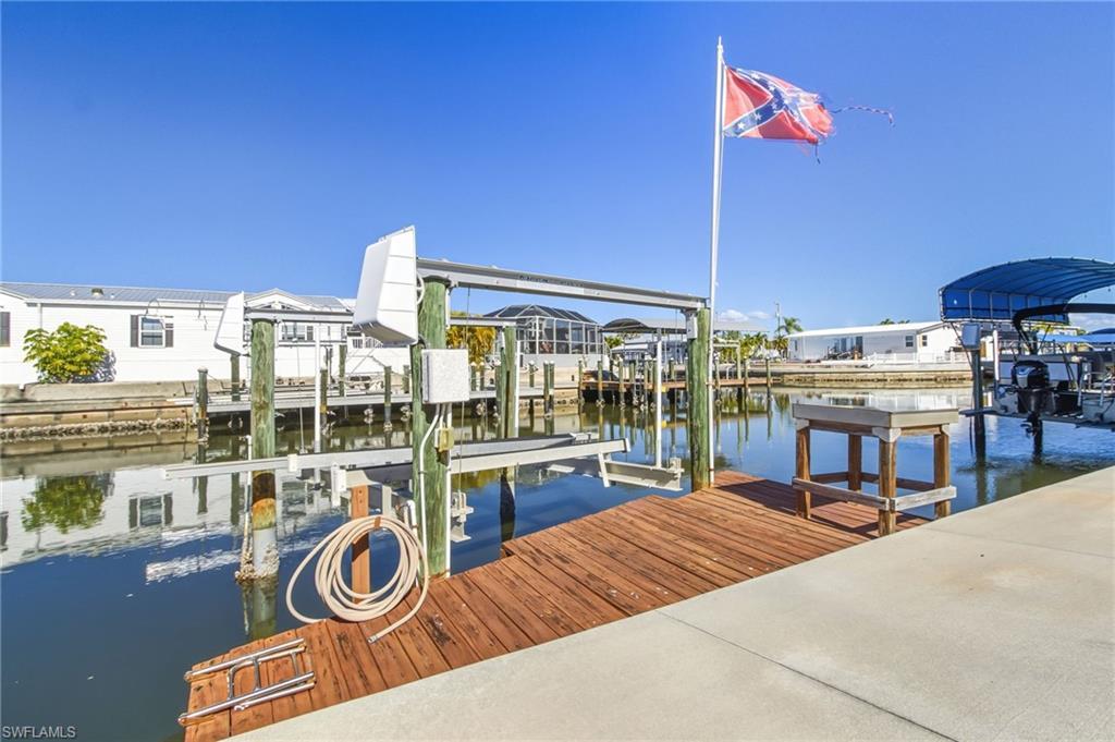 Image 2: Dock area featuring boat lift and a water view