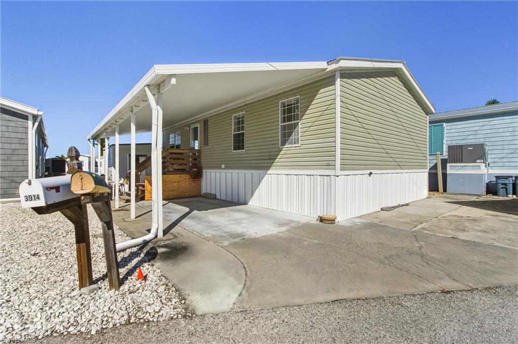 Image 4: View of home's exterior with a carport and driveway