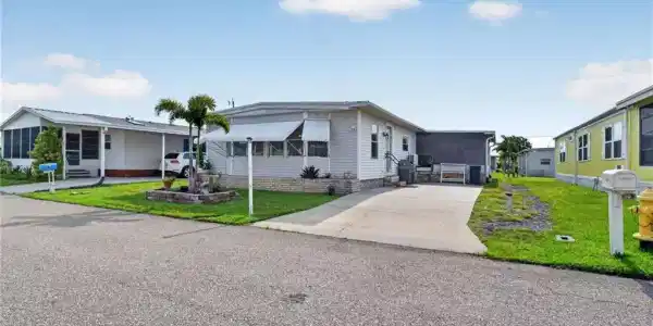 Image 3: Single-story residence featuring light-colored siding and a covered front entry