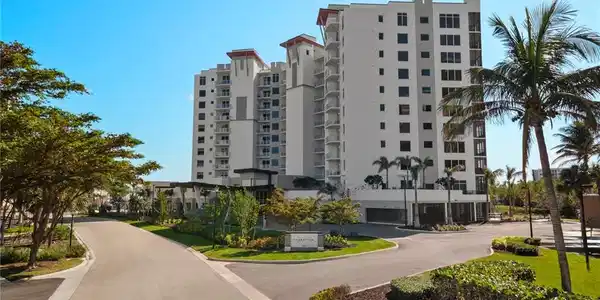 Image 2: Contemporary high-rise fa&ccedil;ade framed by tropical landscaping, palms and bright skies