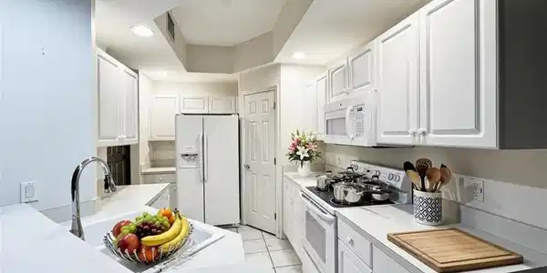 Image 3: Kitchen with white appliances, white cabinetry, light countertops, recessed lighting, and light tile patterned floors