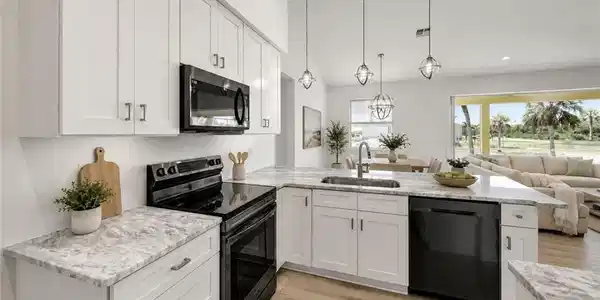 Image 4: Kitchen featuring white cabinetry, light-toned countertops, black appliances, a stainless steel sink with a gooseneck faucet, and wood-finish flooring. virtually staged.