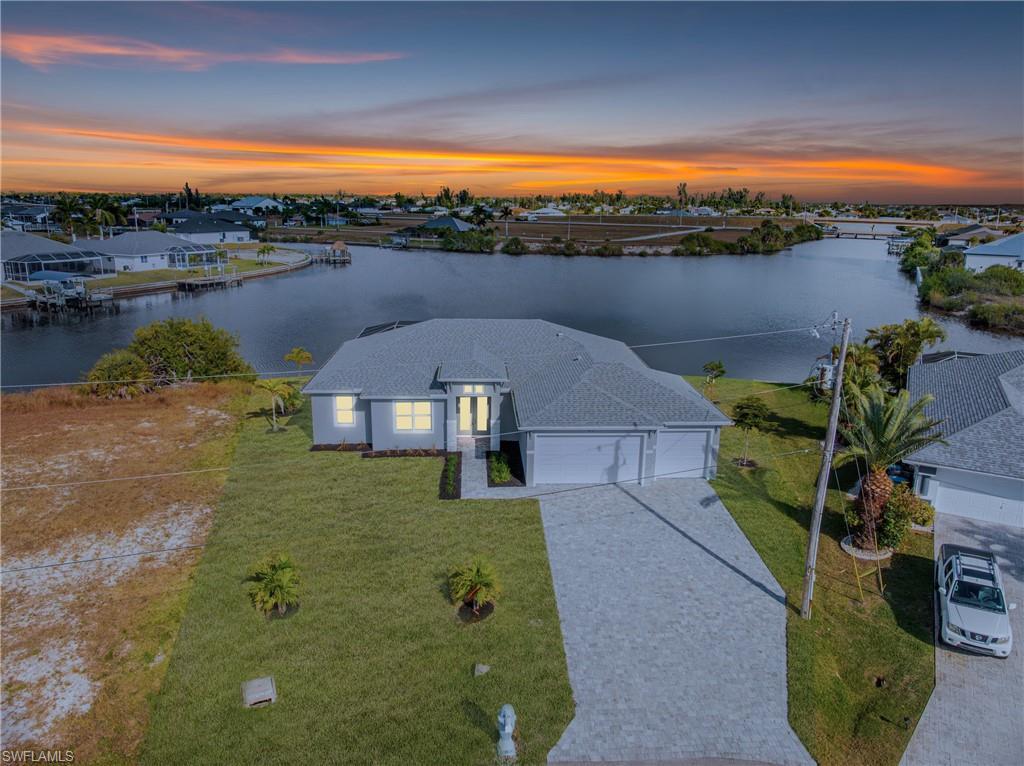 Image 1: Aerial view at dusk of a water view and a residential view