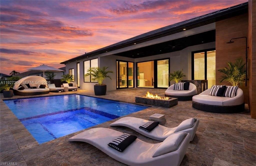 Image 2: Expansive outdoor living area featuring a rectangular pool with an integrated spa, surrounded by large format tile flooring