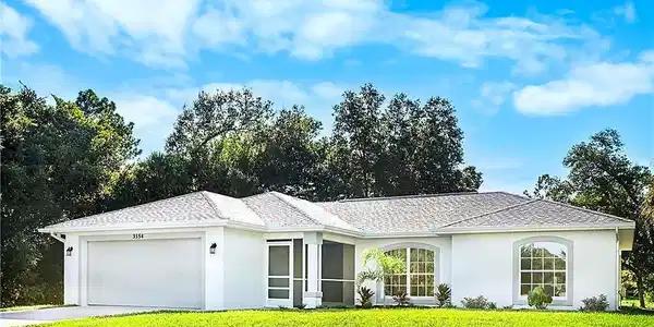 Image 2: White stucco exterior with a gray shingle roof