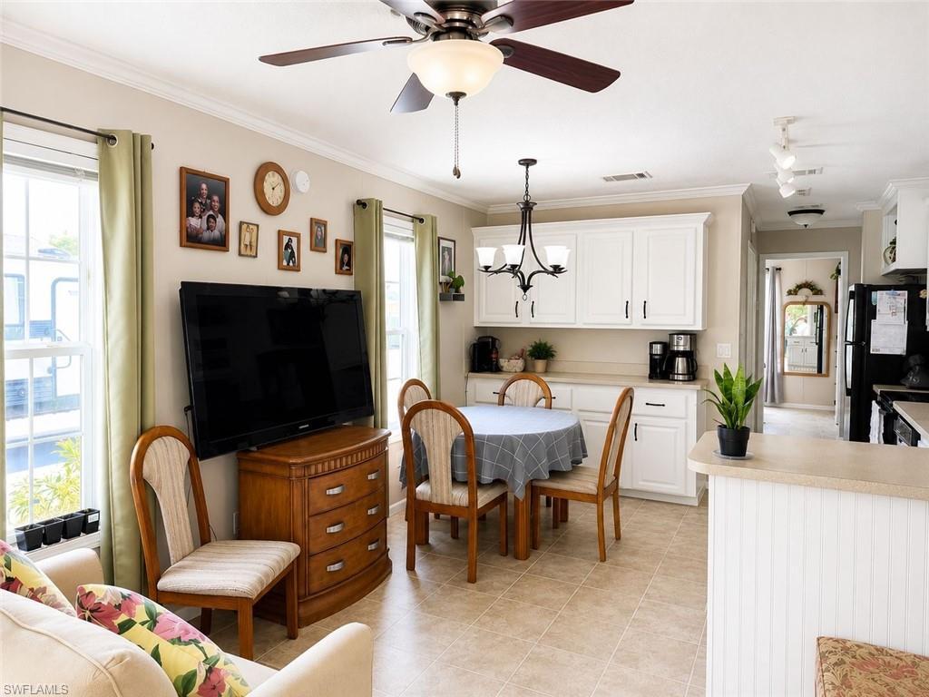 Image 4: Open-concept living area with tile flooring and a ceiling fan