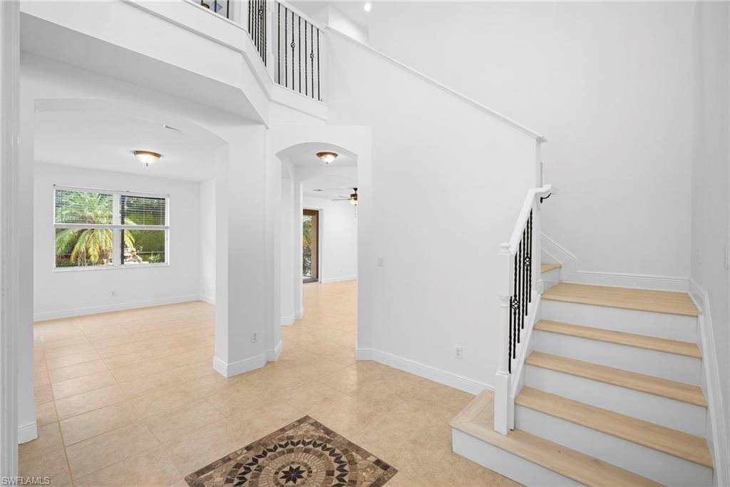 Image 3: Stairway with arched walkways, a high ceiling, a ceiling fan, and tile patterned flooring