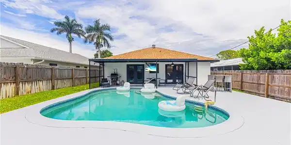Image 2: View of swimming pool with french doors, a fenced backyard, and a patio area