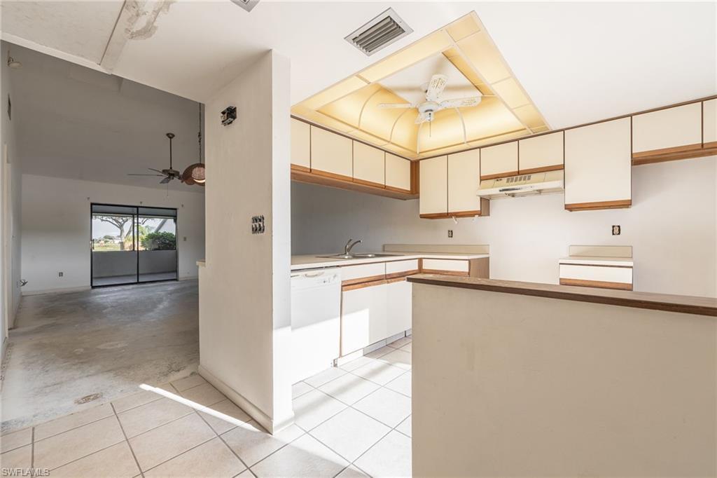 Image 4: Kitchen featuring white cabinetry, white tile flooring, and a drop ceiling with integrated lighting