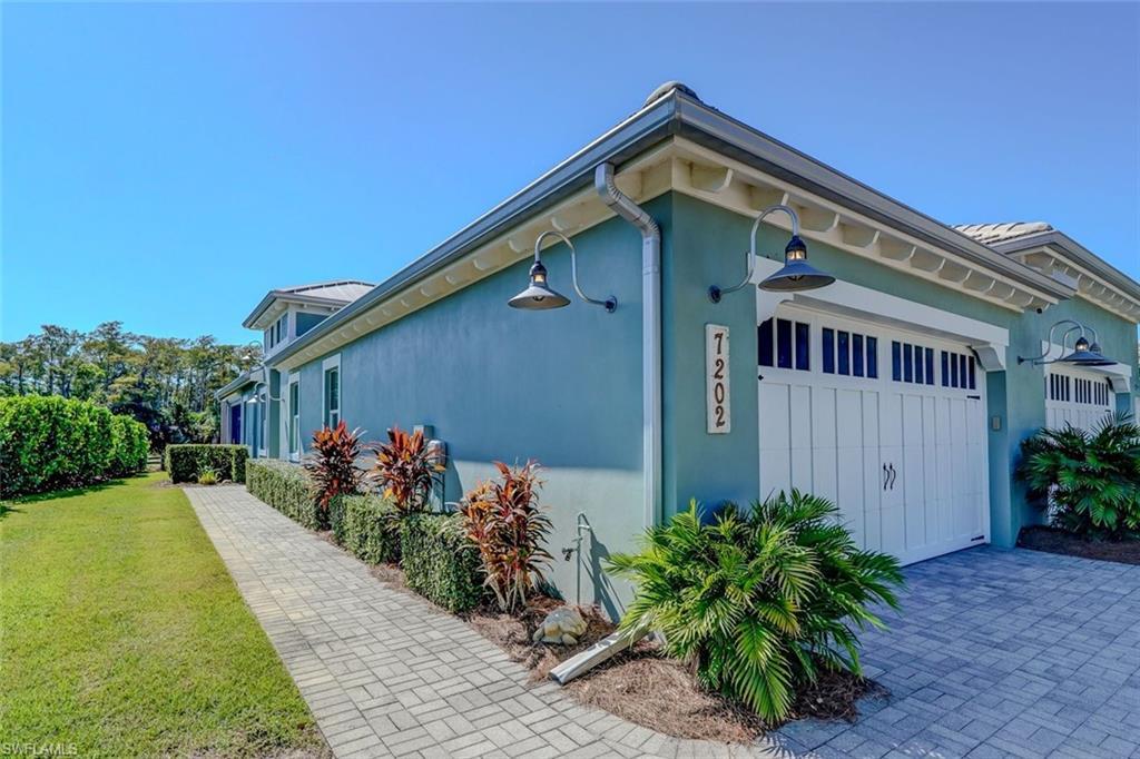 Image 3: View of property exterior featuring stucco siding, a garage, and a lawn