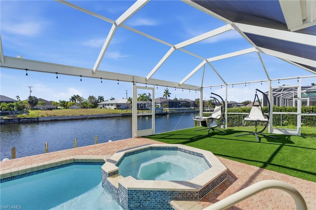Image 2: Integrated pool / spa featuring a water view, a sunroom, a patio, and a lawn