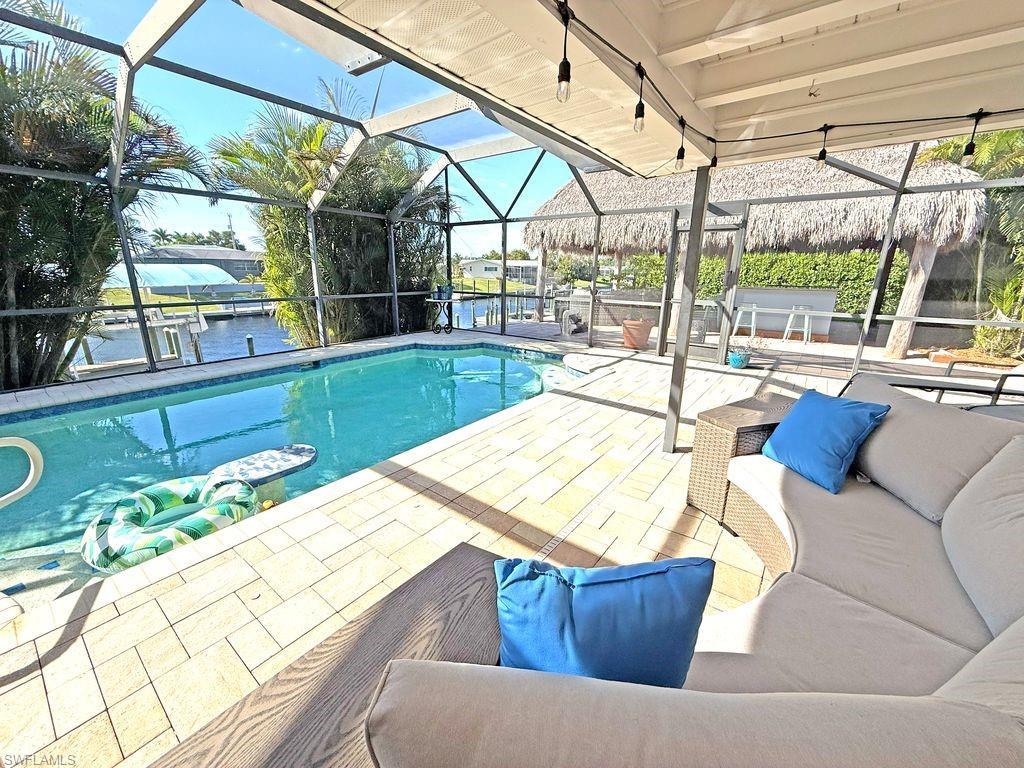 Image 4: Swimming pool featuring a lanai, a water view, a sunroom, and a patio