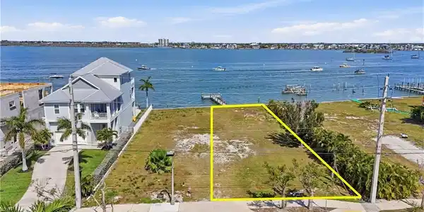 Image 2: Aerial overview of property's location with property parcel outlined and a nearby body of water - Virtually Edited Image