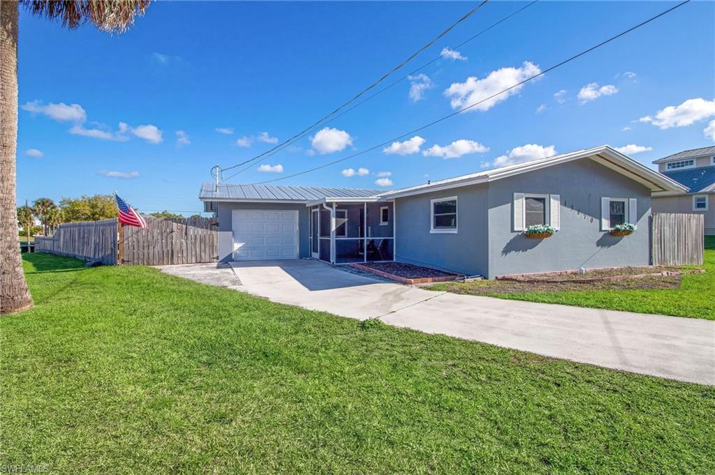Image 2: View of front of property with stucco siding, concrete driveway, an attached garage, and a metal roof