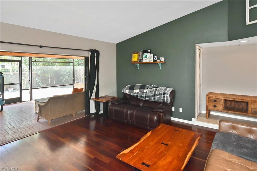 Image 4: Living area with vaulted ceiling and wood finished floors