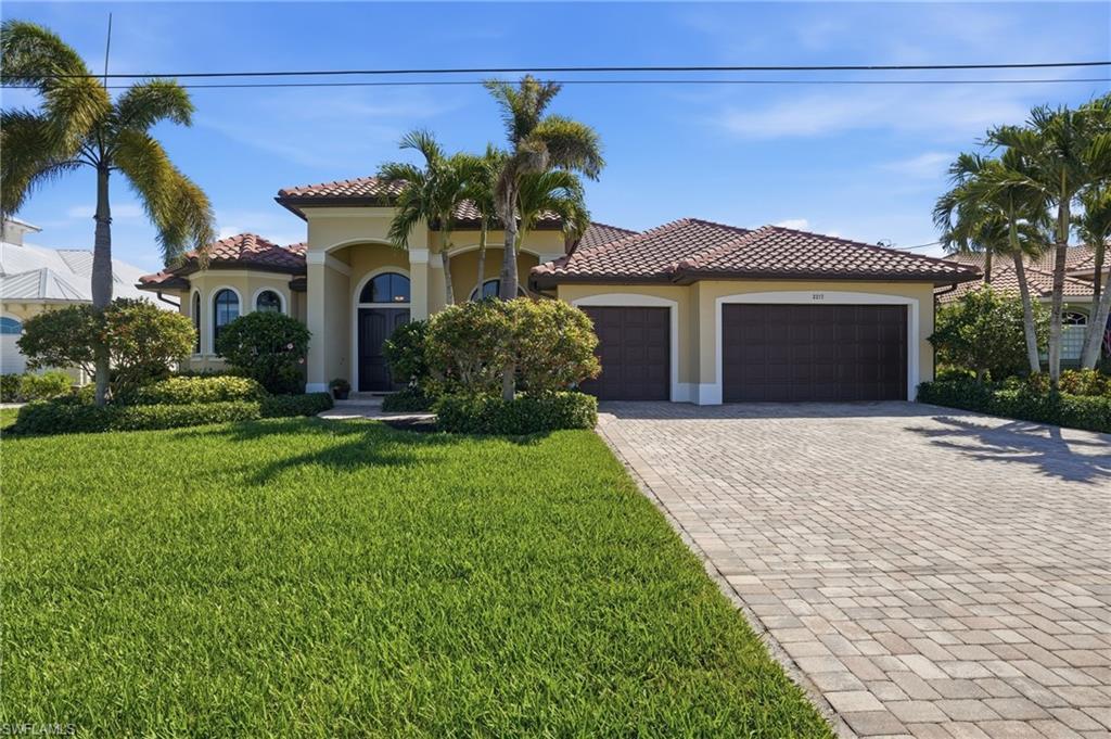 Image 3: Mediterranean / spanish house with decorative driveway, an attached garage, stucco siding, and a front yard