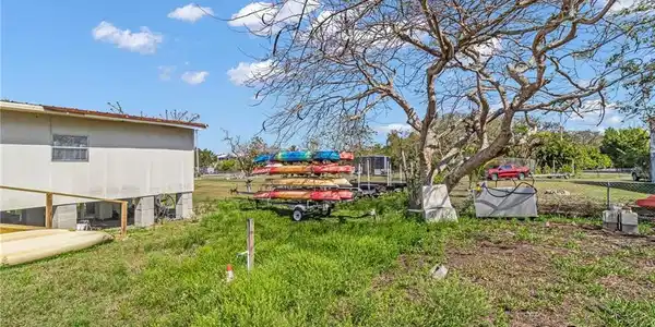 Image 3: View of yard with fence & extra lot in the distance