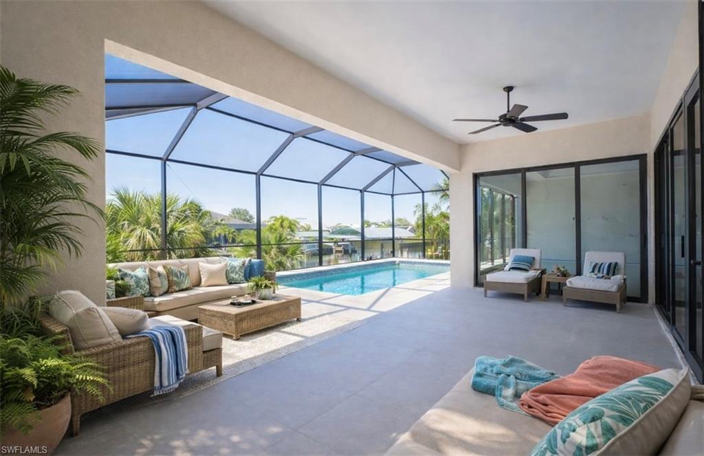 Image 2: Outdoor pool featuring an outdoor hangout area, a sunroom, glass enclosure, and a patio (Rendered photo)