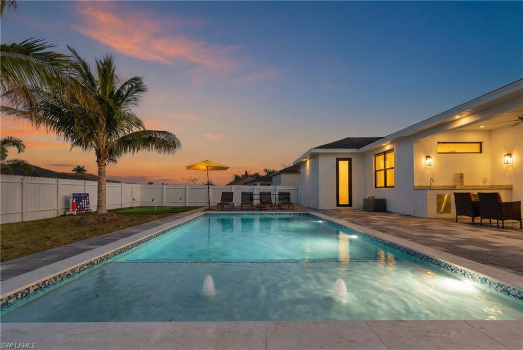 Image 4: View of pool with a patio area, a fenced backyard, and an outdoor bar