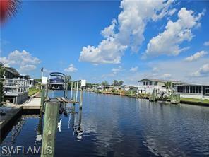 Image 4: Dock area featuring a water view and boat lift