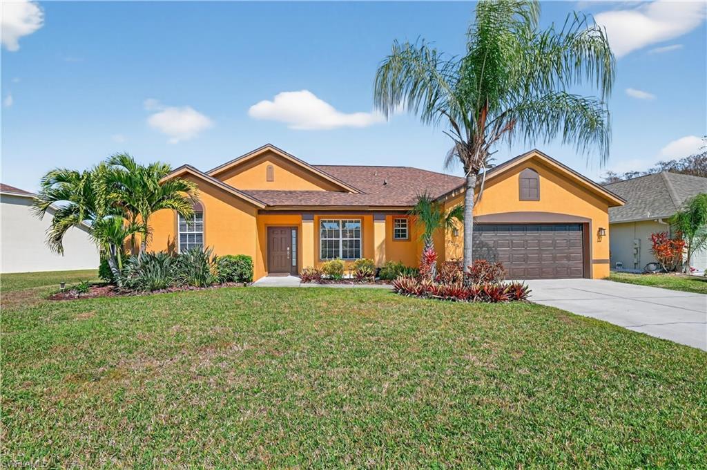 Image 2: Ranch-style house featuring stucco siding, a front lawn, driveway, and an attached garage