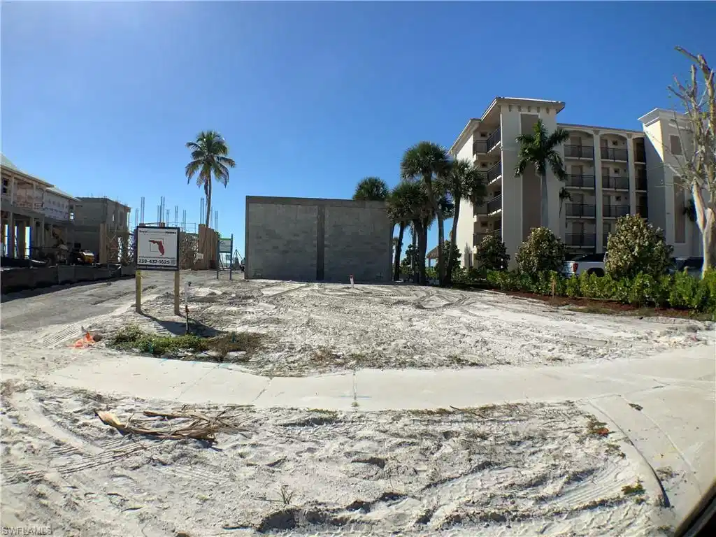 Image 1: Direct look into lot from Estero blvd , concrete wall on back lot line, drive way paved on right side off Estero blvd