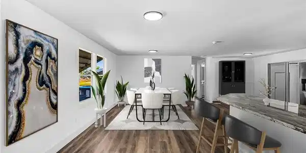 Image 2: Open-concept dining and kitchen space featuring wood-finish flooring, recessed lighting, and a kitchen island with a stone-finish countertop