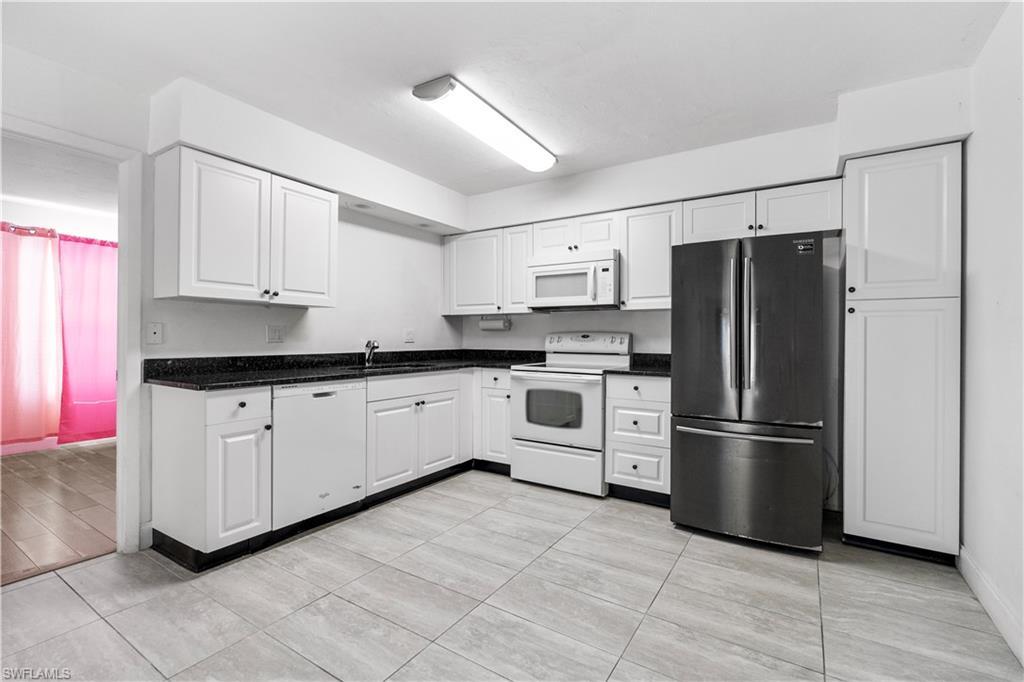 Image 2: Kitchen with white appliances and white cabinets