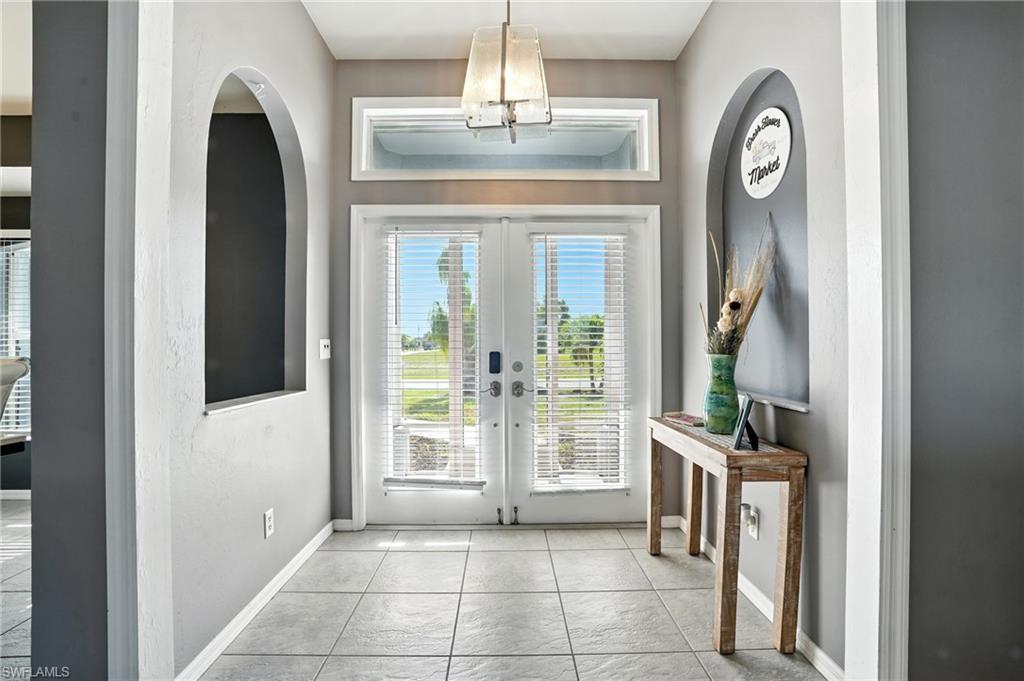 Image 3: Doorway to outside featuring french doors, tile patterned floors, and arched walkways