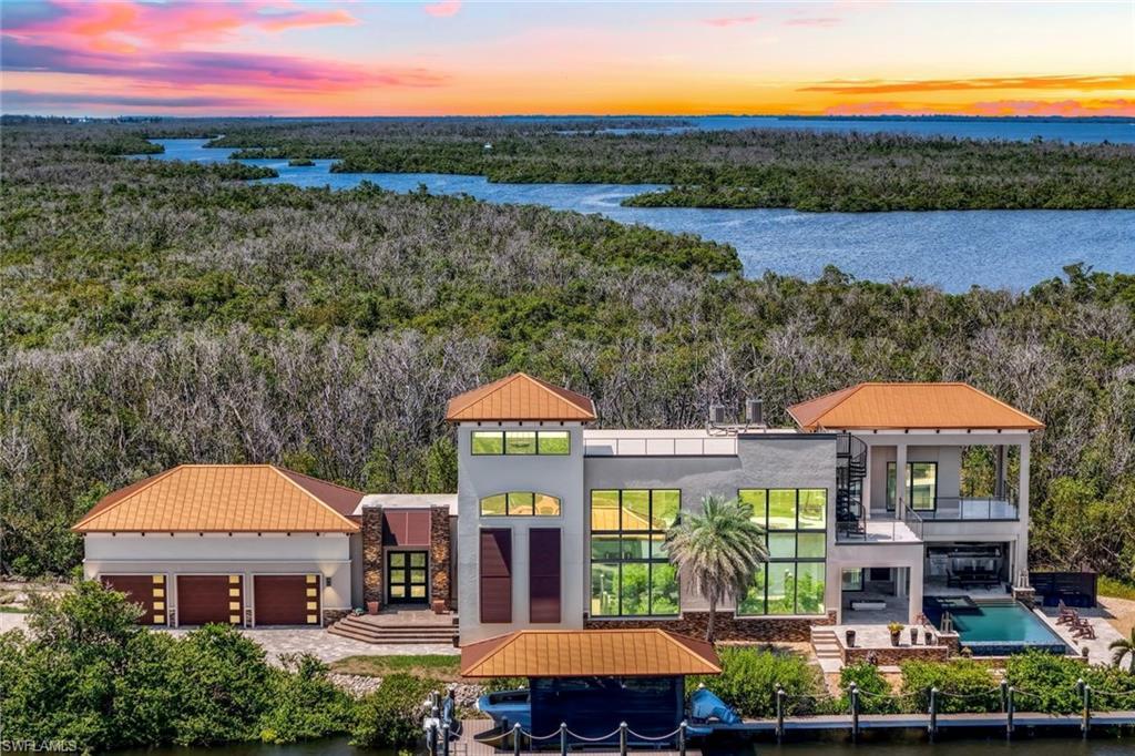 Image 1: View from above of property with a nearby body of water and a heavily wooded area