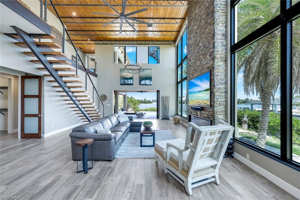 Image 4: Living area with wood finished floors, a chandelier, stairway, healthy amount of natural light, and wood ceiling