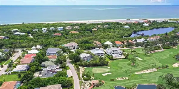Image 3: View of property location with a nearby body of water, nearby suburban area, and a golf course