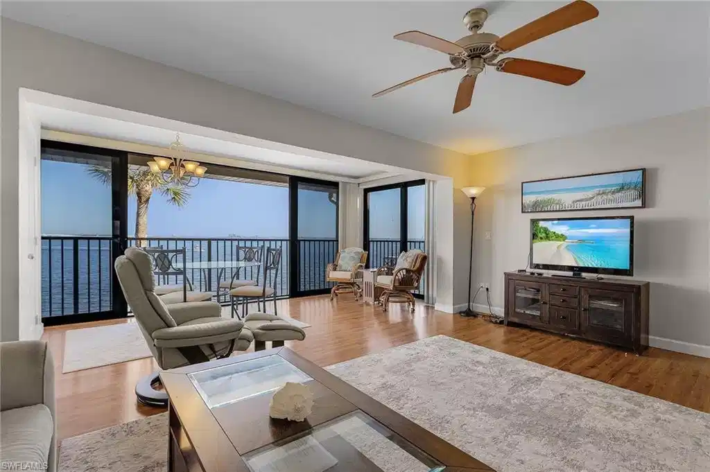 Image 1: Living room with hardwood / wood-style floors and ceiling fan with notable chandelier