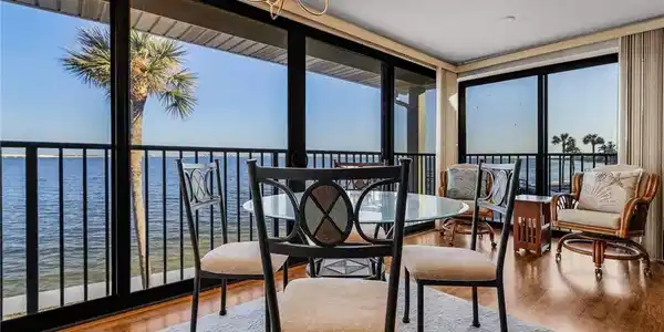 Image 2: Sunroom / solarium with a notable chandelier and a water view