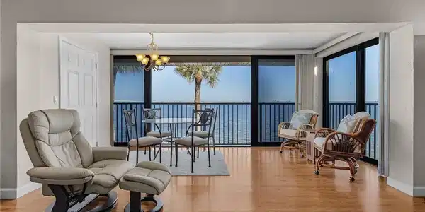 Image 3: Living area featuring a notable chandelier, wood-type flooring, and a water view