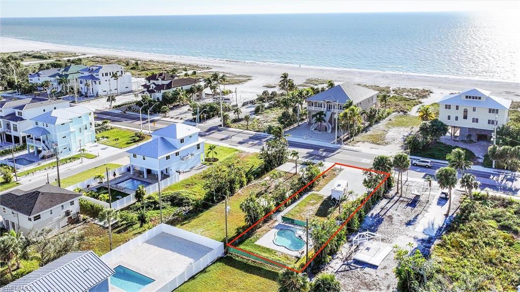 Image 1: Aerial view of property and surrounding area with property parcel outlined and expansive beach
