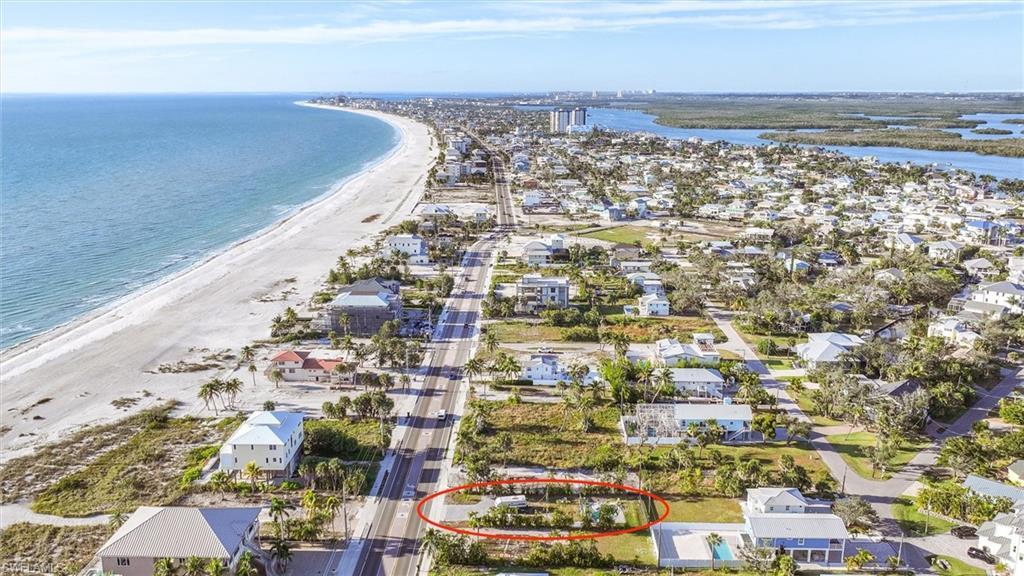 Image 2: Aerial perspective of suburban area featuring waterfront with a beach