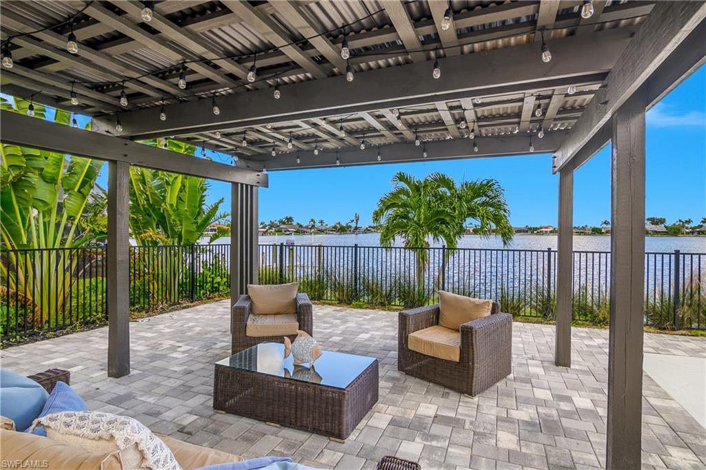 Image 3: Fenced backyard with outdoor lounge area, a water view, and a patio