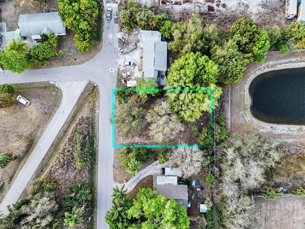 Image 1: Aerial view of property and surrounding area with property parcel outlined and a nearby body of water