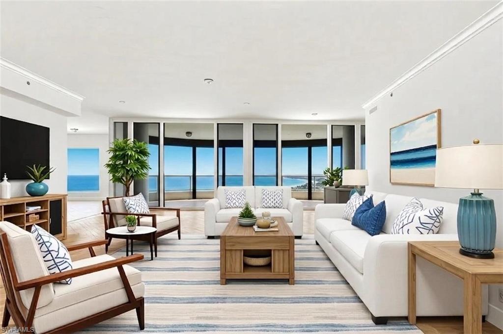 Image 2: VIRTUALLY STAGED. Spacious living area featuring expansive windows, wood-finish flooring, recessed lighting, crown molding, and a built-in entertainment console