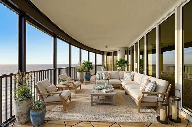 Image 4: VIRTUALLY STAGED. Expansive curved balcony featuring floor-to-ceiling windows, black metal railings, and a textured ceiling
