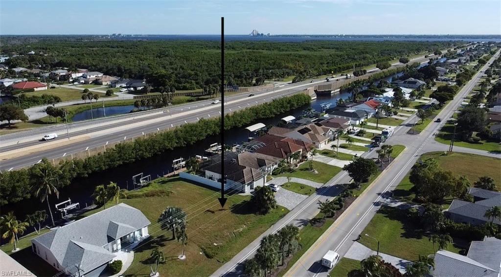 Image 1: Aerial perspective of suburban area featuring a highway and a large body of water