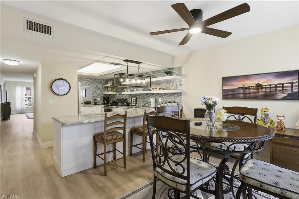 Image 3: Open-concept living space featuring wood-finish flooring and a contemporary ceiling fan