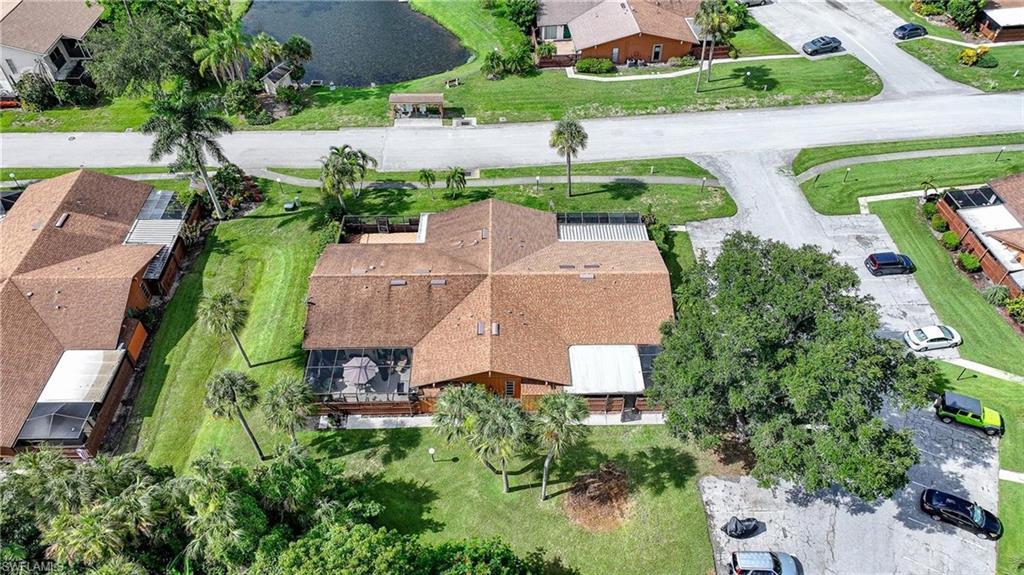 Image 2: Property featuring a brown shingle roof, a screened patio, and mature landscaping