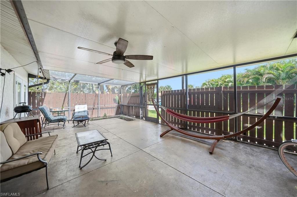 Image 4: Screened patio featuring a ceiling fan, concrete flooring, and a privacy fence