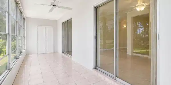 Image 4: Enclosed patio featuring light-toned tile flooring, white walls, and a ceiling fan