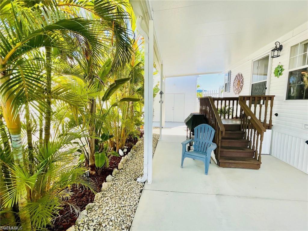 Image 2: Covered outdoor patio with a staircase leading to an elevated entrance